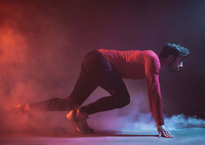 Fit athlete crouched in runner's start position